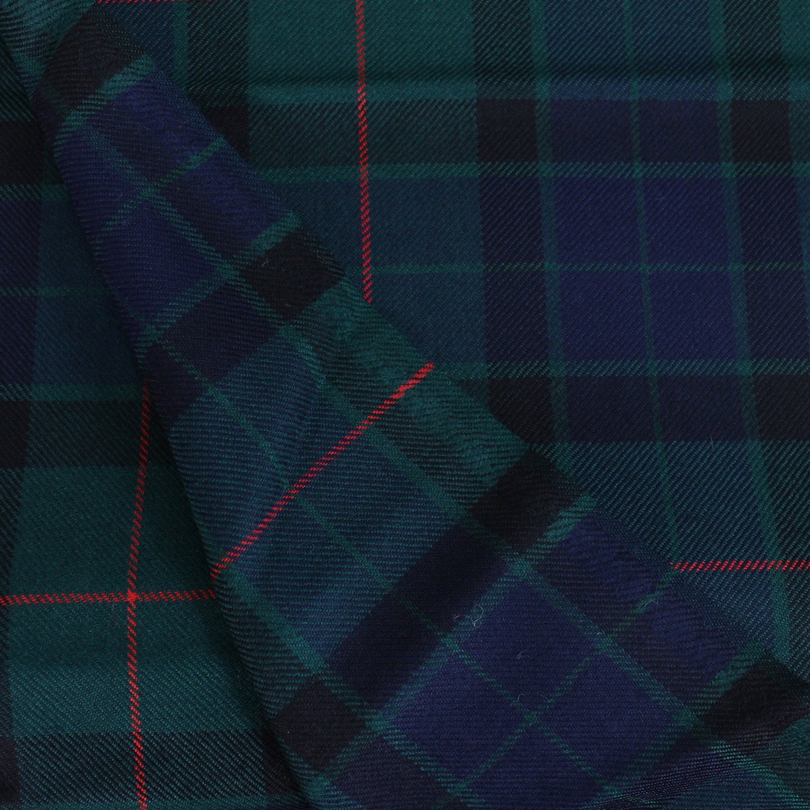 Close up view of soft navy and green cotton flannel plaid fabric with red overcheck