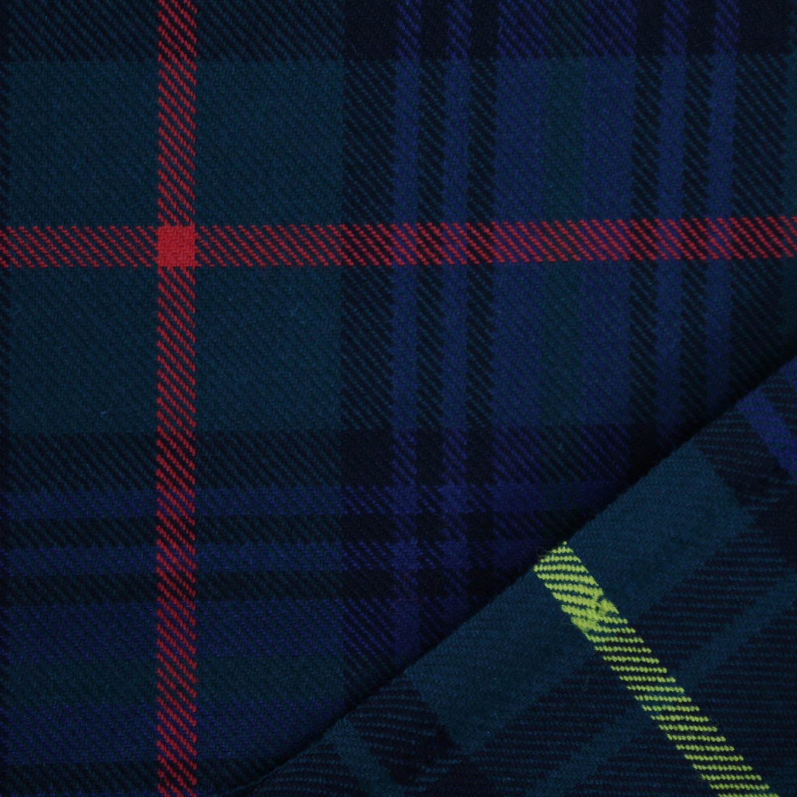 Detailed view of soft navy and green tartan flannel material with red accents