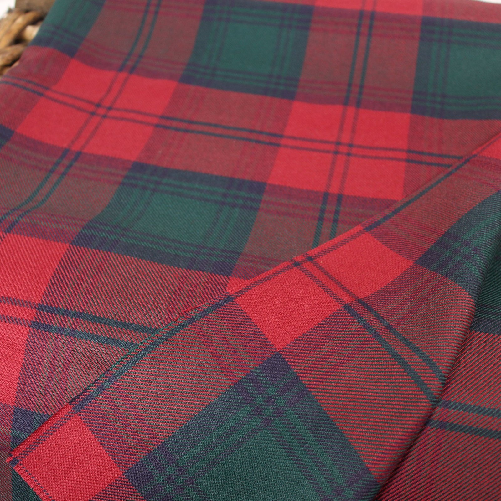 Close-up of MacGregor Tartan wool fabric showing a vibrant red base with dark green and black intersecting stripes in a twill weave.